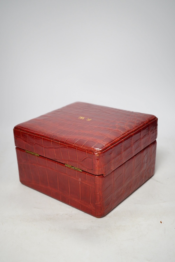 An early 20th century crocodile skin vanity case with glass jars, 21.5cm wide. Condition - fair, no key